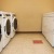 a room with a row of washing machines and dryers